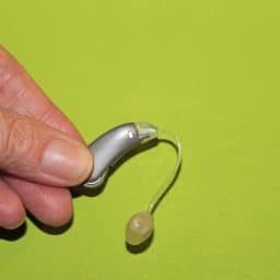 reciever-in-ear-hearing aid in front of green background