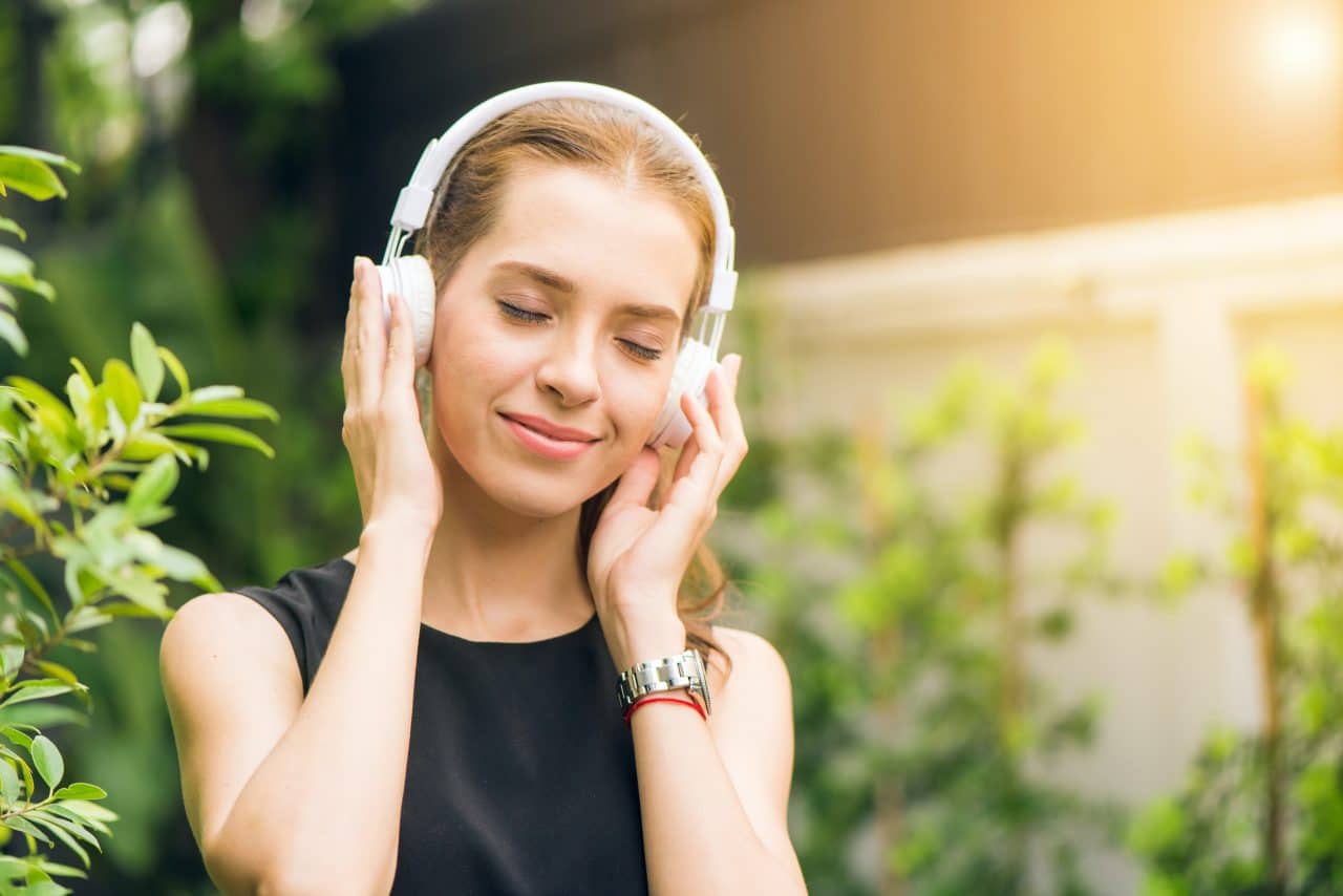 Woman smiling and listening to music with her headphones.