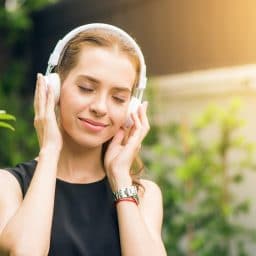Woman smiling and listening to music with her headphones.