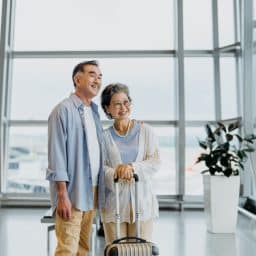 a senior couple stands together at the airport
