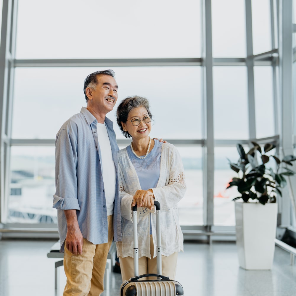 a senior couple stands together at the airport