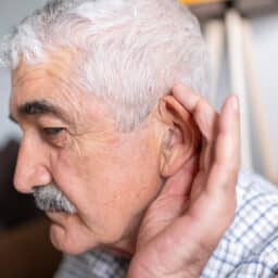 Man cups ear to hear better