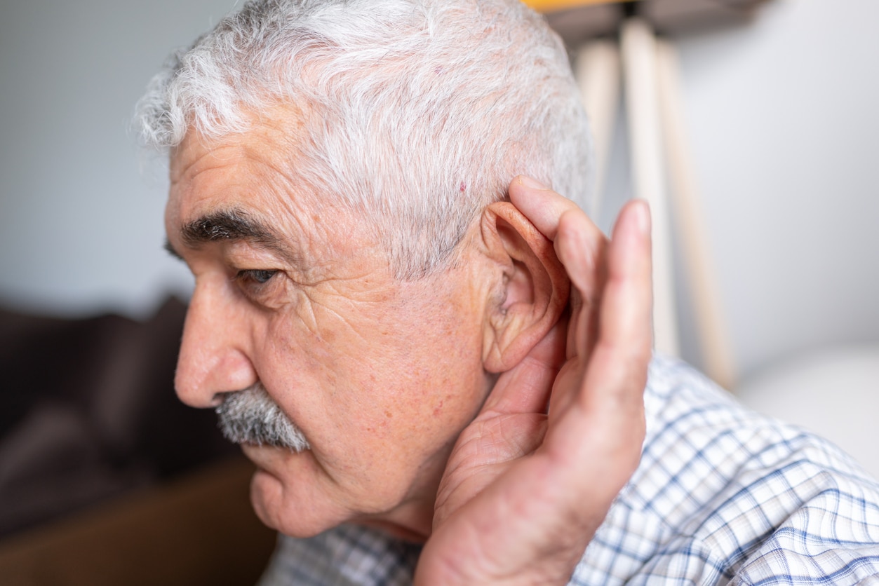 Man cups ear to hear better