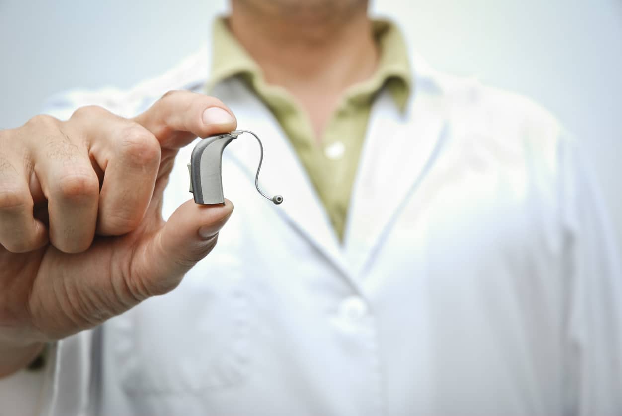 Hearing specialist holds hearing aid