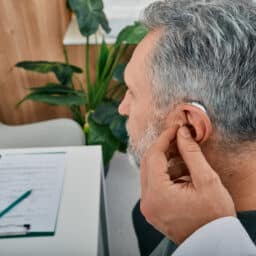 Man trying on new hearing aid.