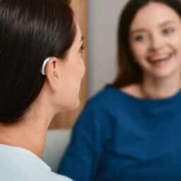 Woman with treated hearing loss listens to friend