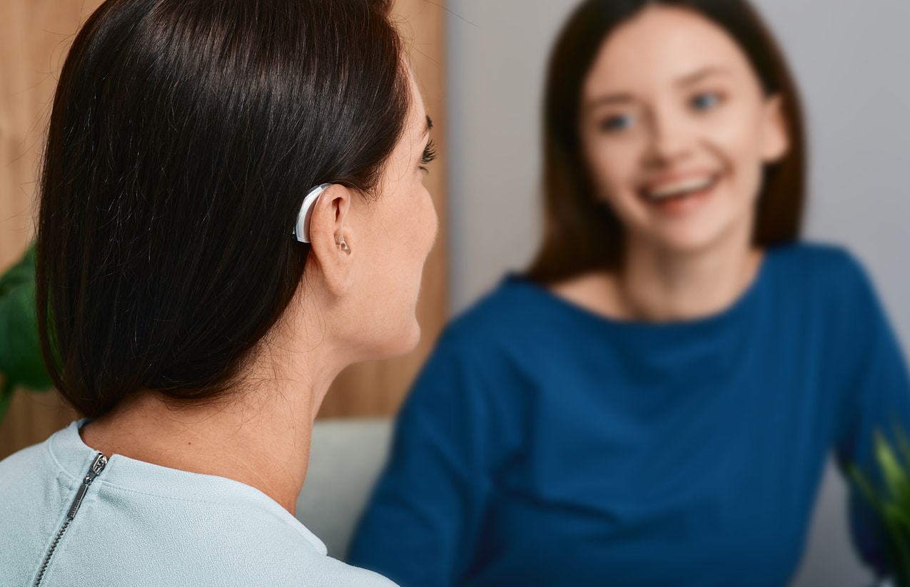 Woman with treated hearing loss listens to friend