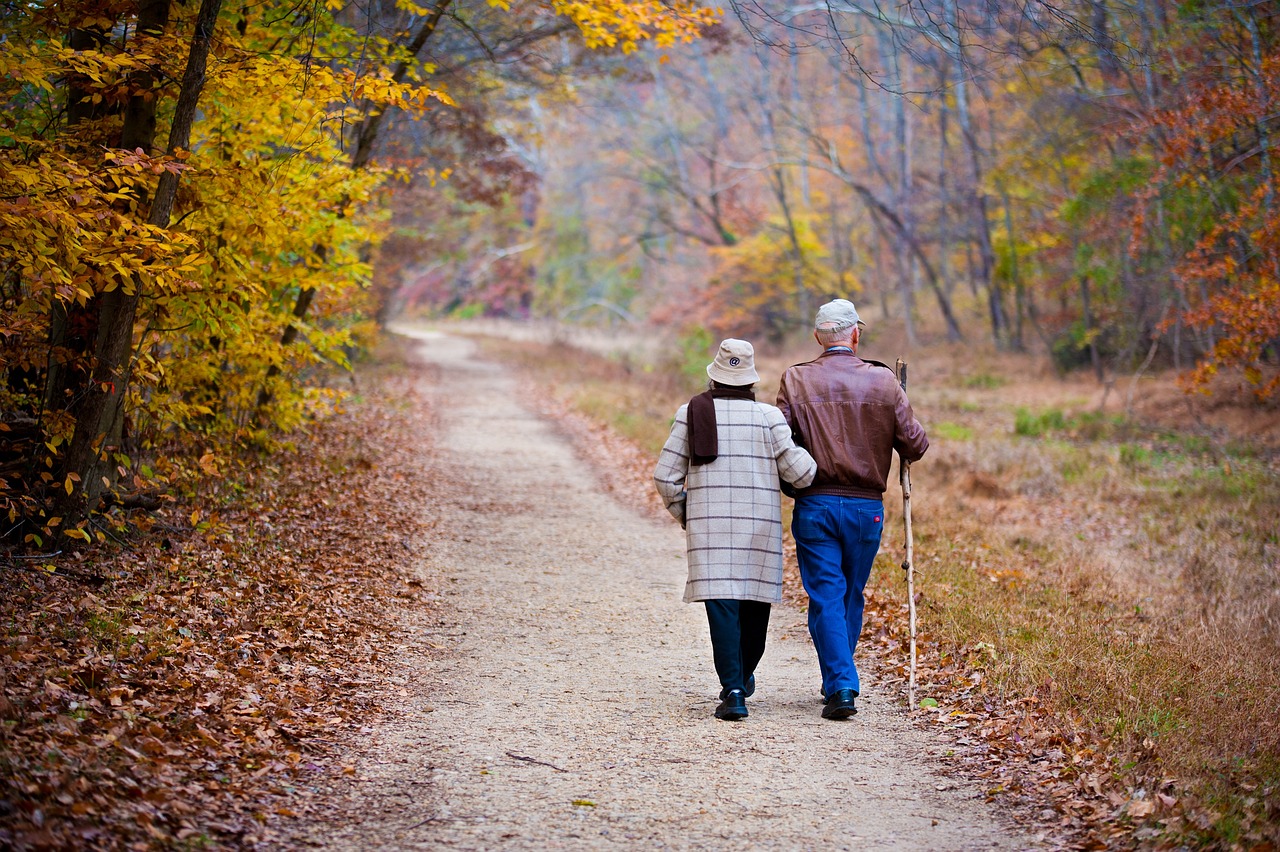 older couple walking down a train in the fall