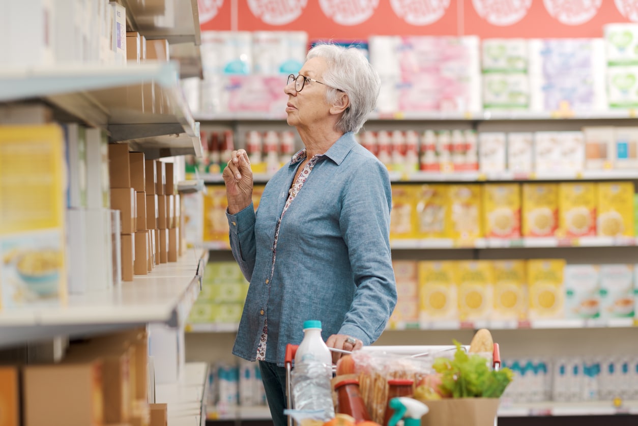 Senior woman grocery shopping at the supermarket.